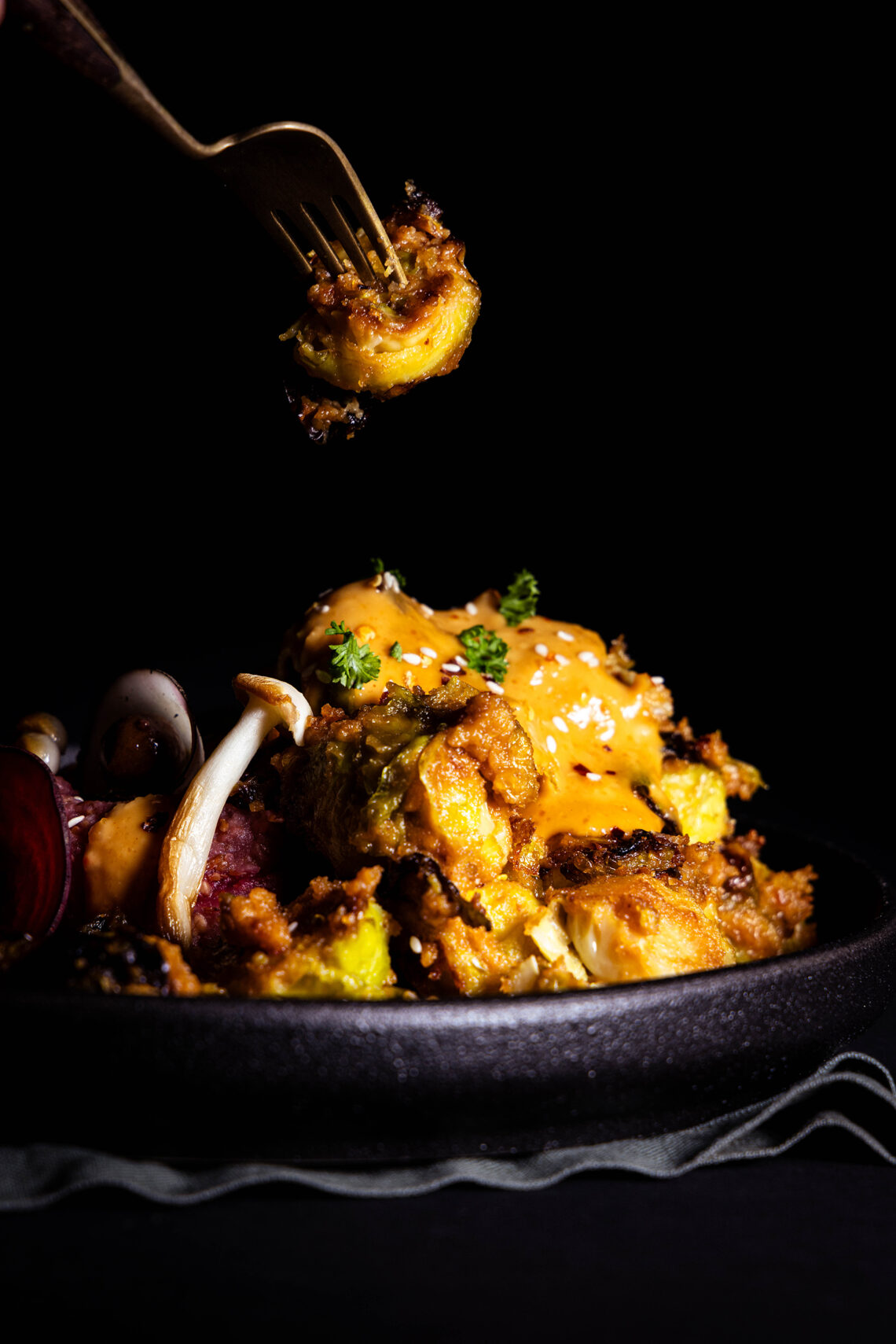 Brussels sprouts in peanut sauce, one on a fork